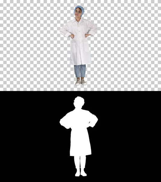 Доктор женщина с руками на бедрах, стоя, расслабленной и улыбаясь, очень позитивный и веселый, Альфа-канал — стоковое фото