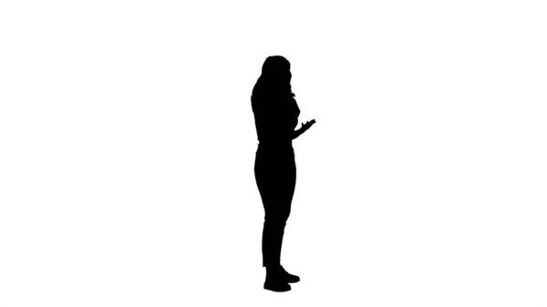 Silhouette Νεαρή γυναίκα μιλάει στο κινητό τηλέφωνο. — Φωτογραφία Αρχείου