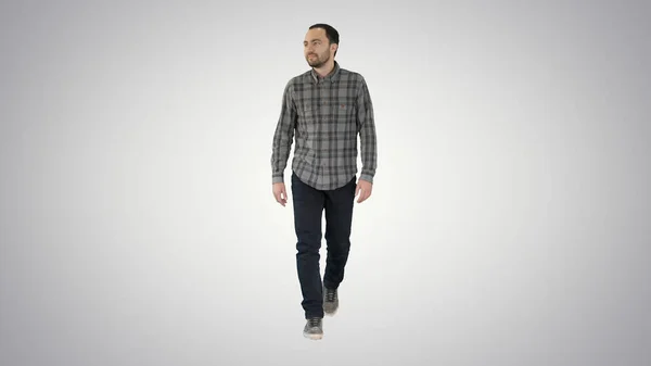 Relaxed casual man in jeans and shirt walking and looking to the sides on gradient background. — Stock Photo, Image