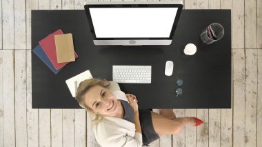 Gözlüklü başarılı genç bir kadın bilgisayarla masada oturuyor. Sonra kameraya bakar ve bir konuşma yapar. Beyaz Görünüm.