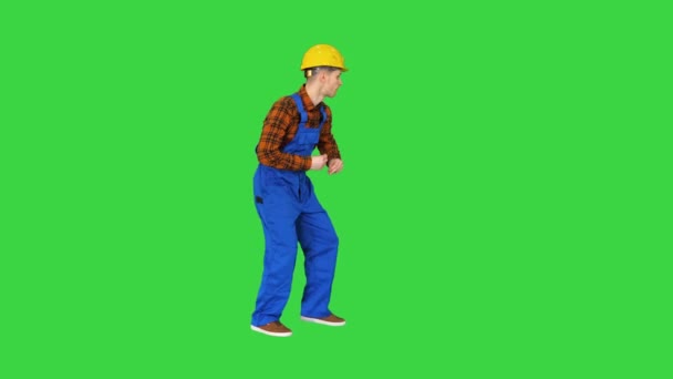 Jonge bouwvakker in harde hoed dansend hip-hop op een groen scherm, Chroma Key. — Stockvideo