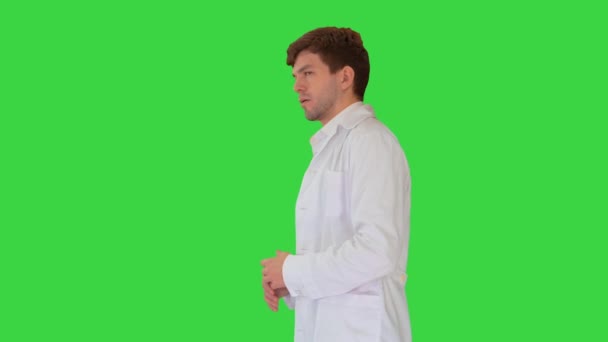 Dokter draagt witte jas met uitleg over iets op een groen scherm, Chroma Key. — Stockvideo