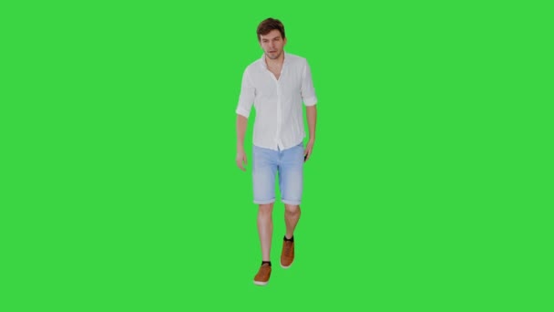 Erschöpfter junger Mann leidet unter Hitze beim Gehen auf einem Green Screen, Chroma Key. — Stockvideo