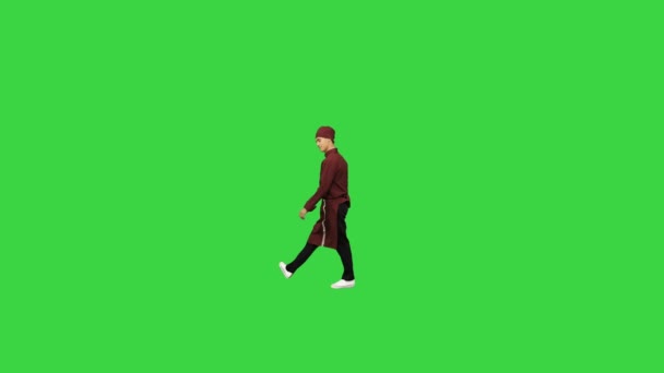 Повар-мужчина в красной форме танцует брейк-данс с лопаткой и делает вращения рук на зеленом экране, хрома-ключ. — стоковое видео