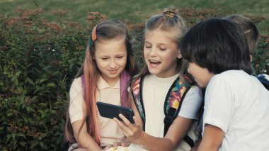 Mutlu çocuklar telefonda video izlemekten zevk alıyorlar..