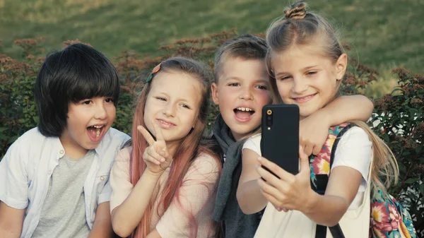 Δροσερά παιδιά βγάζουν selfie χαμογελώντας και κάνοντας χειρονομία νίκης. — Φωτογραφία Αρχείου