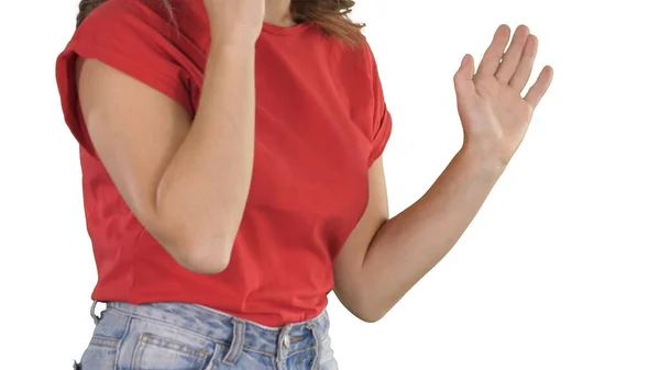 Mulher de t-shirt vermelha fazendo gestos enquanto fala no telefone no fundo branco. — Fotografia de Stock