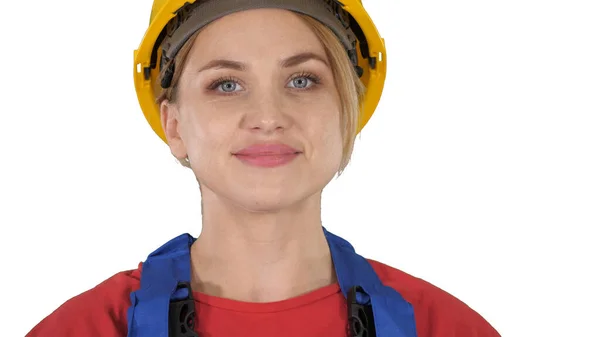 Mujer joven en hardhat amarillo caminando sobre fondo blanco. — Foto de Stock