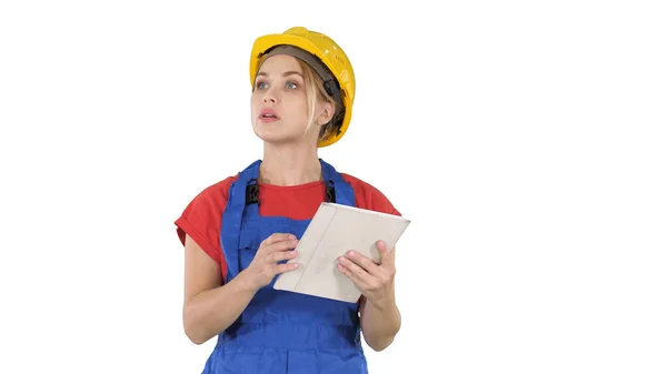 Engenheira mulher verificando o plano de construção no touchpad e olhando para objetos, edifícios em torno dela no fundo branco. — Fotografia de Stock