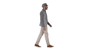 Beyaz arka planda yürüyen şapkalı sıradan bir Arap..