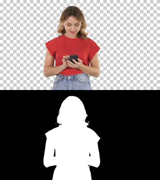 Jonge mooie vrouw in t-shirt met behulp van haar smartphone, Alpha Channel — Stockfoto