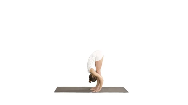 Bella modella che fa esercizio di yoga in piedi in Uttanasana con palme alle spalle delle caviglie su sfondo bianco. — Foto Stock