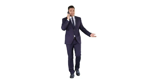 Успешный человек в костюме говорит по телефону и ходит на белом фоне. — стоковое фото
