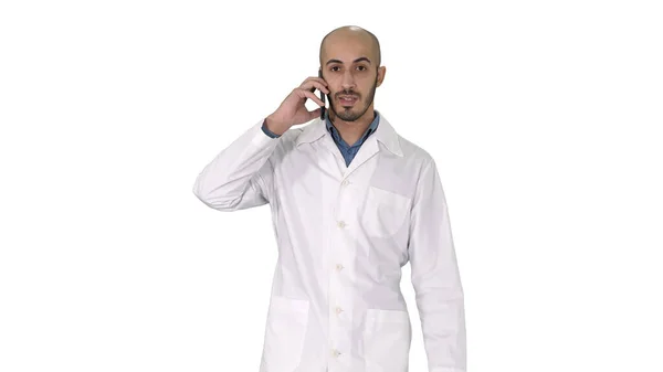 Dokter medis profesional berbicara di telepon genggam ketika berjalan di atas latar belakang putih. — Stok Foto
