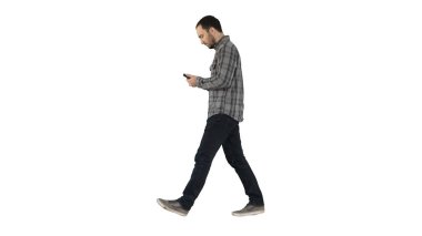 Beyaz arka planda cep telefonunda yürüyen ve mesajları okuyan zeki bir genç..