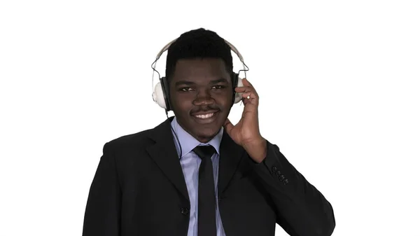 Guapo afroamericano hombre de negocios en auriculares está escuchando música sobre fondo blanco. —  Fotos de Stock