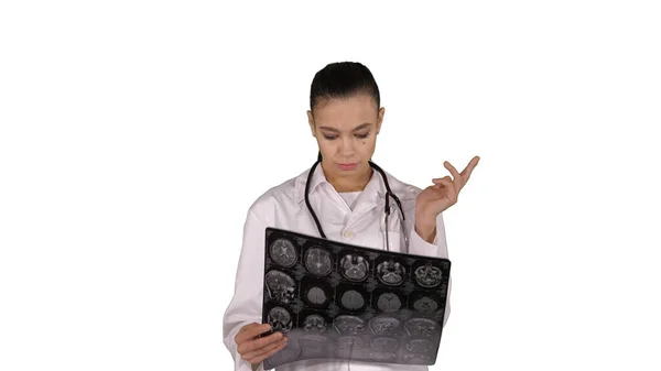 Doutor fêmea com labcoat branco, olhando para a imagem radiográfica de raios X, tomografia computadorizada, ressonância magnética em fundo branco. — Fotografia de Stock