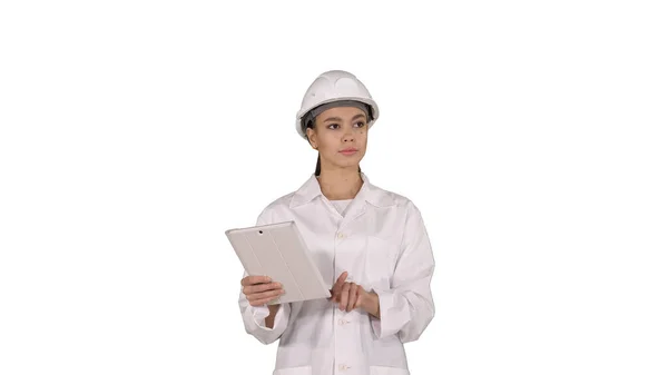 Donna ingegnere controllare le informazioni e gli oggetti sul suo tablet su sfondo bianco. — Foto Stock
