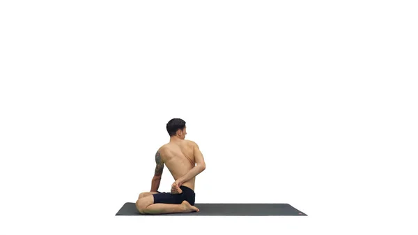 Un jeune homme fort faisant des exercices de yoga étire les jambes de padmasana sur fond blanc. — Photo