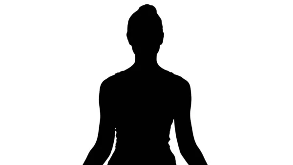 Silhouette Junge Frau sitzt in Lotus-Pose und meditiert mit geschlossenen Augen. — Stockfoto