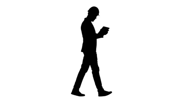 Silhouette Engenheiro andando e trabalhando em tablet digital. — Fotografia de Stock
