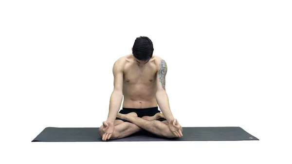 Giovane uomo che pratica yoga in posizione di loto su sfondo bianco. — Foto Stock