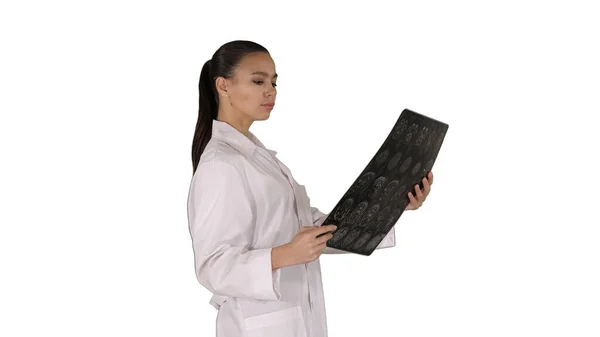 Intellektuell kvinna vårdpersonal med vit labcoat, tittar på röntgen röntgen bild, ct scan, MRI på vit bakgrund. — Stockfoto