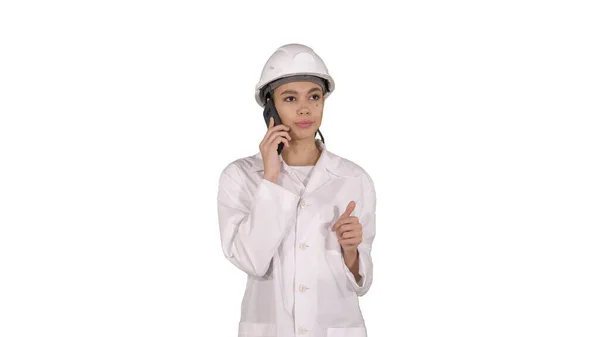 Kobieta inżynier rozmawia przez telefon podczas chodzenia na białym tle. — Zdjęcie stockowe