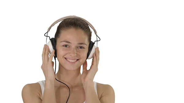 Mosolygó fiatal nő hallgat zenét fejhallgató fehér háttér. — Stock Fotó