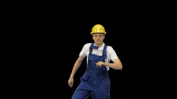 Jonge bouwvakker in geel hardhat break dansen kijken naar camera, Alpha Channel — Stockvideo