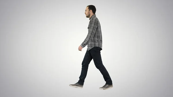 Jovem homem casual andando sobre fundo gradiente. — Fotografia de Stock