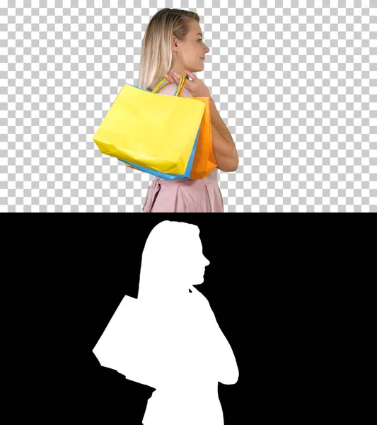Alışveriş merkezine başlayalım Pembe elbiseli kadın alışveriş torbalarıyla geziyor, Alpha Channel — Stok fotoğraf