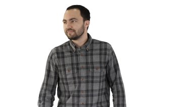 Yakışıklı başarılı genç girişimci beyaz arka planda yürürken ve yandan bakarken.