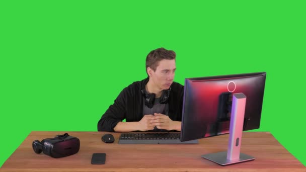 Giocatore serio seduto al computer a guardare una partita su uno schermo verde, Chroma Key. — Video Stock