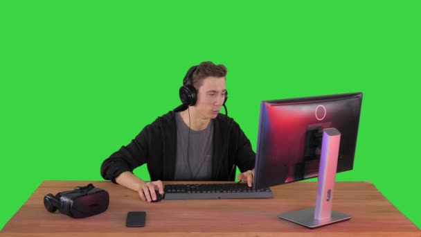 Professionele Gamer speelt video game op zijn computer en commentaar op zijn stroom op een groen scherm, Chroma Key. — Stockvideo