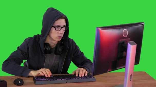 Hacker en gafas rompiendo código en una pantalla verde, Chroma Key. — Vídeo de stock