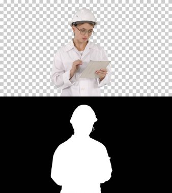 Düşünceli, düşünceli genç mühendis tableti Alpha Channel ile çalışıyor.