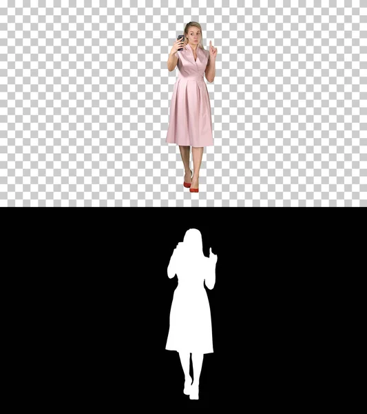 Lächelnde Frau im rosa Kleid beim Videoanruf und Gehen, Alpha Channel — Stockfoto