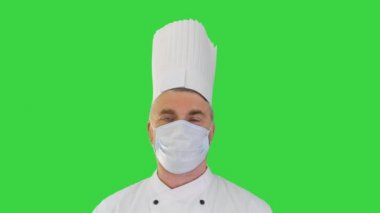 Erkek aşçı, Yeşil Ekran, Chroma Key 'de virüs hastalığından korunmak için yüz koruyucu maske takıyor..