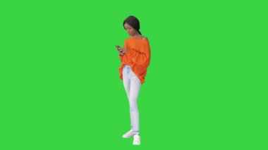 Telefonunu yeşil ekranda kullanan güzel bir genç kadın, Chroma Key..