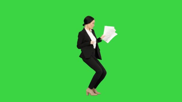Spännande affärskvinna dansar med en massa papper i handen på en grön skärm, Chroma Key. — Stockvideo
