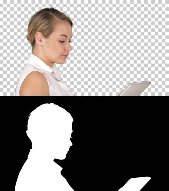 Tek başına yürüyen ve medya içeriğini tablet Alfa Kanalı 'nda seyreden bir kız.