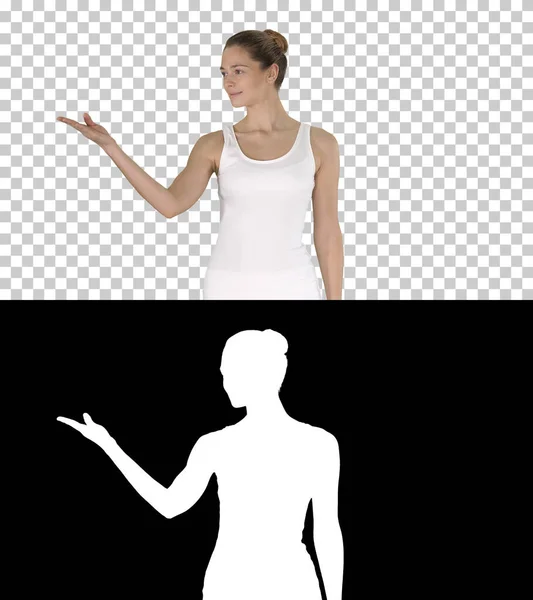 Mujer en blanco camiseta blanca caminando y mostrando algo a un lado, Alpha Channel — Foto de Stock