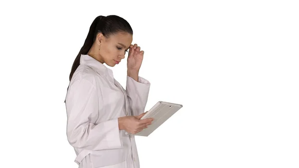 Mujer médico usando tableta PC y caminando sobre fondo blanco. — Foto de Stock