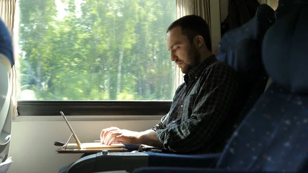 Man working on laptop tablet computer in train. — Stock Photo, Image
