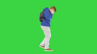 Günlük kıyafetlerle gezen ve yeşil ekranda tıbbi maskeyi çıkaran okul çocuğu, Chroma Key..