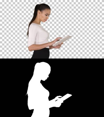 Yürürken dijital tablet kullanan çekici iş kadını, Alpha Channel