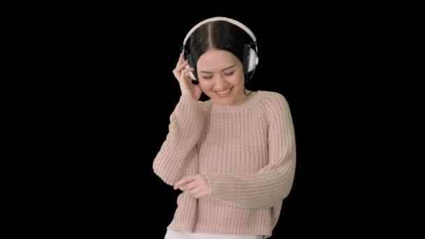 Lächelnde Frau mit Kopfhörern, die zur Musik läuft und tanzt, Alpha Channel — Stockvideo