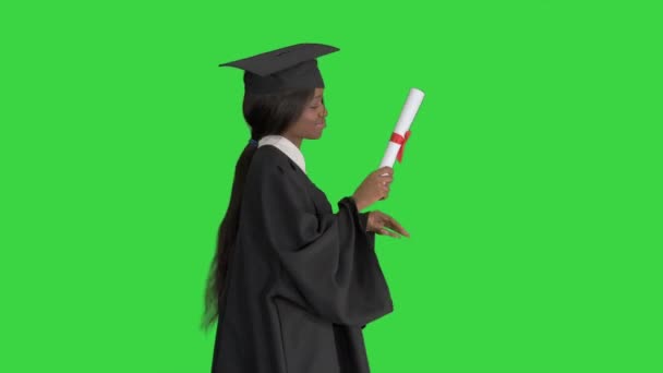 O femeie absolventă afro-americană fericită dansând cu diploma pe un ecran verde, Chroma Key . — Videoclip de stoc