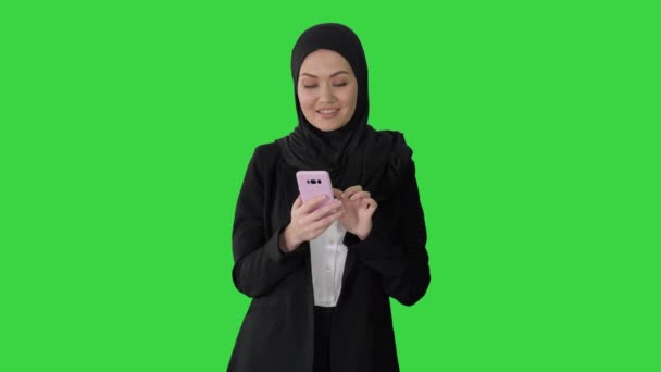 Улыбающаяся арабская женщина с помощью смартфона на зеленом экране, Chroma Key. — стоковое видео